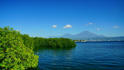 A view from Bali strait to Java island. Bali Strait is a stretch of water separating Java and Bali while connecting the Indian Ocean and the Bali Sea. 