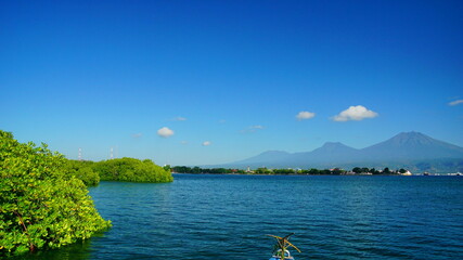 A view from Bali strait to Java island. Bali Strait is a stretch of water separating Java and Bali while connecting the Indian Ocean and the Bali Sea. 