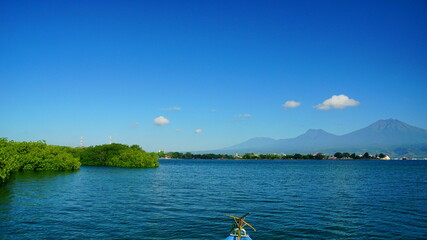A view from Bali strait to Java island. Bali Strait is a stretch of water separating Java and Bali while connecting the Indian Ocean and the Bali Sea. 