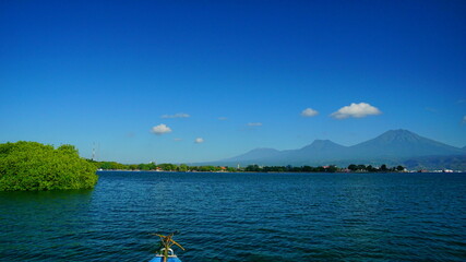 A view from Bali strait to Java island. Bali Strait is a stretch of water separating Java and Bali while connecting the Indian Ocean and the Bali Sea. 