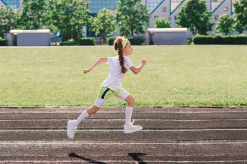 Girl jogging on a sunny summer evening, laying on treadmill, stadium, physical training, back to school.