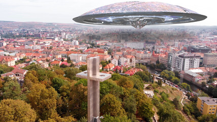 Alien ufo flying Saucers over Large City in Europe, Aerial Red rooftops city in europe with large church cross © ImageBank4U