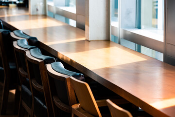 Row of working table with chair by the glass window.