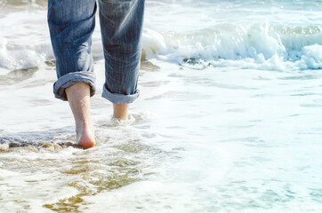 detail of man's legs and feet in sea water