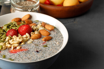 Chia pudding with strawberry and pumpkin seeds on wooden table