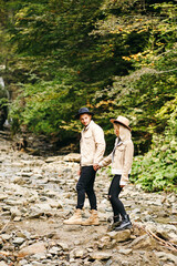 Young couple at the Carpathian - Happy tourists visiting mountains. Lovestory. Tourists in hats. Military fashion.