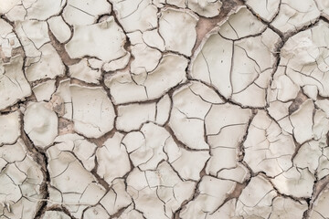 Pattern dry ground soil field that is broken from drought in the summer close-up.