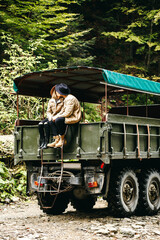 A beautiful girl and a handsome man in military truck. Lovestory. Military vehicle. Military fashion.Carpathian mountains