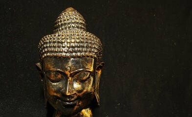 golden bust of buddha on a dark background