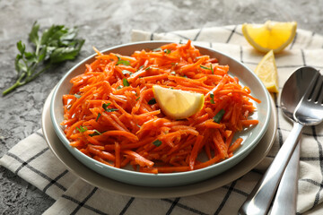 Composition with tasty carrot salad on gray background. Korean carrot