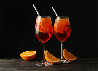 Composition with aperol spritz cocktail against black background
