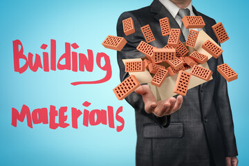 Anonymous businessman levitating cardboard box with lots of red perforated bricks flying out of it on blue background with title 'Building Materials'.