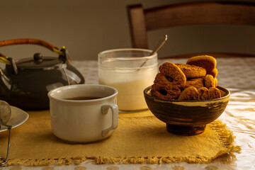 Taza de té negro con azúcar, limones y galletas en el fondo de la mesa rústica
