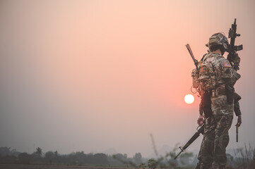 Team special forces. soldier assault rifle with silencer.Silhouette action soldiers hold weapons.military and danger concept.