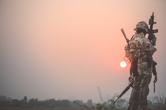 Team special forces. soldier assault rifle with silencer.Silhouette action soldiers hold weapons.military and danger concept.