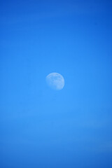 Moon in daylight on blue sky