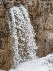Waterfall flowing from a rock by the sea