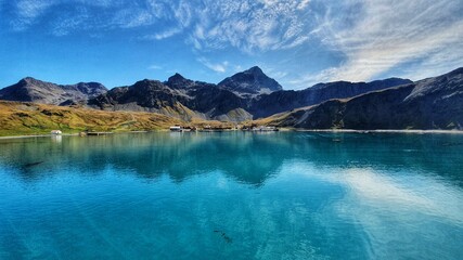 Dramatic landscape shot of Grytviken in South Georgia with blue skies and turquoise water
