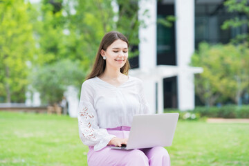 屋外でノートパソコンを操作する女性