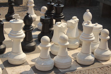 Chess game with chessboard and pawns on the street. Business concept
