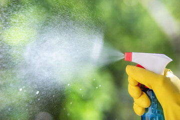 Hand sprays a cleaning agent from a spray .