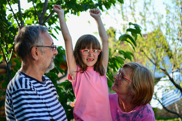 Caucasian grandparent and granddaughter having fun outdoors. grandparents with joyful grandkid in...