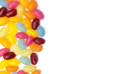 Assorted colors jelly beans background on white. Copy space on right.