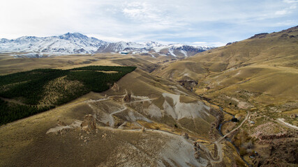 Traveling towards Volcano Domuyo in the Andes mountain range. Aerial view of the dirt road uphill...