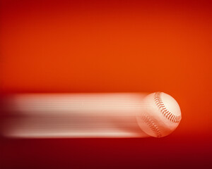baseball in motion with motion streaks on a red background 