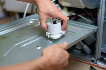 handyman repairs dishwasher with screwdriver