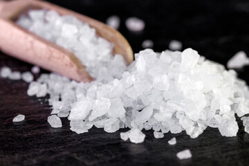 Photo of with Large salt crystals in a wooden spoon. Close up .