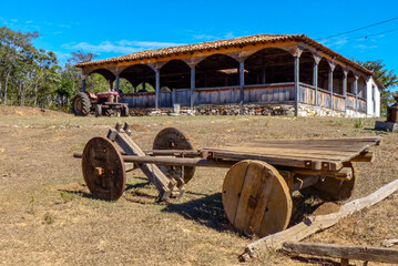 Obraz premium Old ox cart, made entirely of wood, with colonial farmhouse and old tractor, City of Diamantina, State of Minas Gerais, Brazil