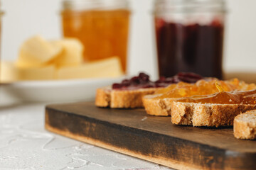 Slice of bread covered with fruit jam on wooden board
