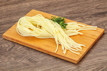 Chechil spaghetti cheese over board