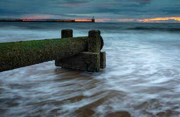 Disused wast pipe on Blyth Beach, Northumberland, England, UK. On overcast morning at dawn, with...