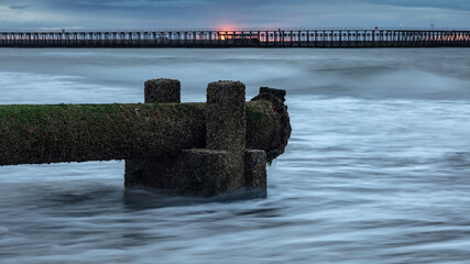 Disused wast pipe on Blyth Beach, Northumberland, England, UK. On overcast morning at dawn, with...