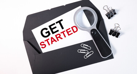 get startrd. text on a business card on a black envelope. business concept