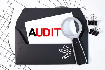 Fototapeta premium AUDIT, text on a business card on a black envelope. business concept.