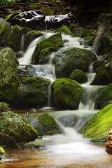 A cool cascade of water falls over granite boulders in a mountain stream in the Blue Ridge Mountains of Virginia