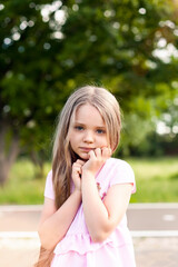 a little girl on a walk in the Park looks at the camera.