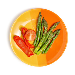 Grilled asparagus and peppers on a yellow-orange plate. White isolated background. Flat lay. The concept of proper nutrition.