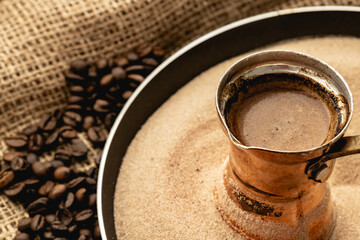 Turkish coffee prepared in sand with turk