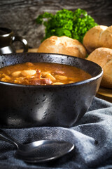 Beans with tomato sauce, bacon and sausage.