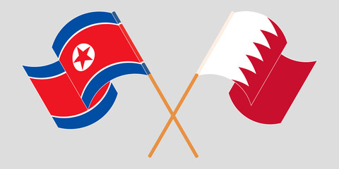 Crossed and waving flags of North Korea and Bahrain