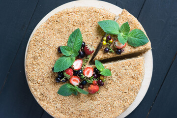 Homemade honey cake with sour cream and berries on top