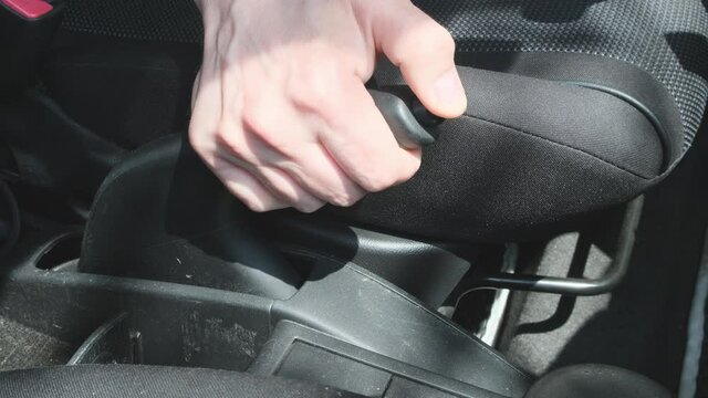 Putting on the hand brake of a car Close up