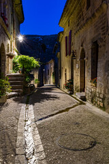 Ruelle médiévale dans le village de Saint-Guilhem-le-Désert la nuit (Occitanie, France)