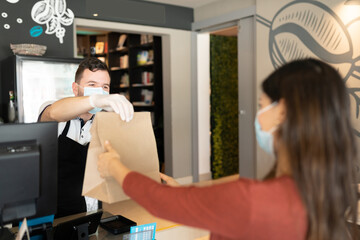 Barista Giving Parcel To Woman