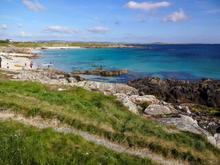 A view of the Irish coast near Clifden in Ireland showing the green grass, rocks and the blue ocean