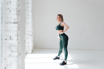 Sporty woman in activewear showing muscular body in studio